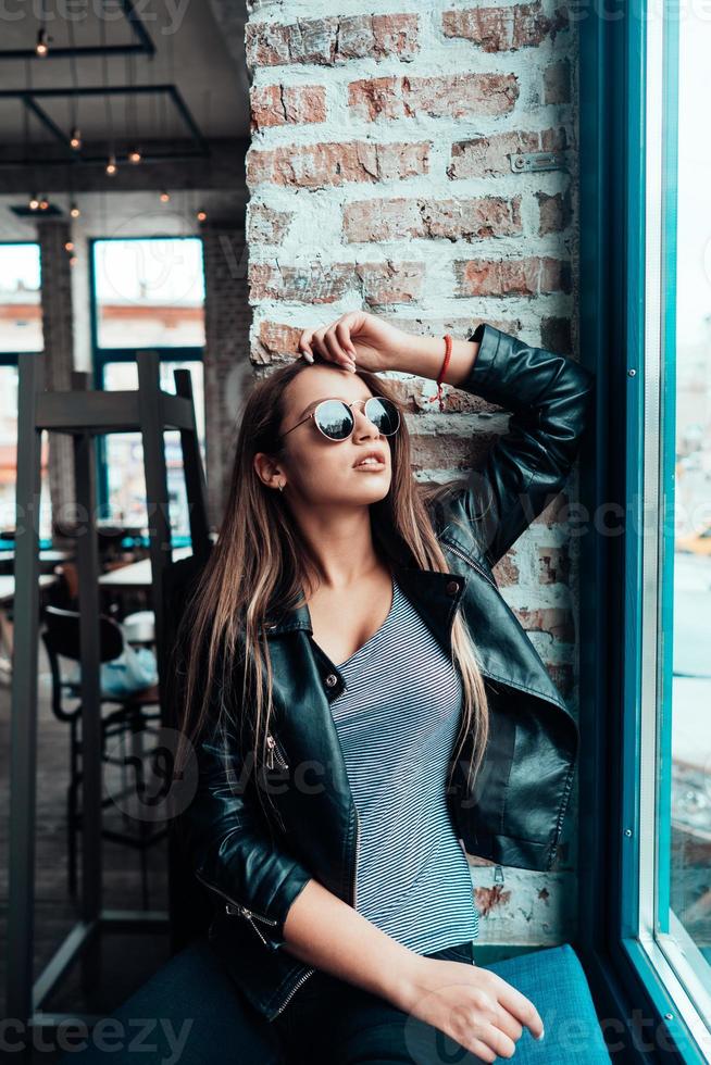 hermosa chica con gafas de sol posando en la cámara foto