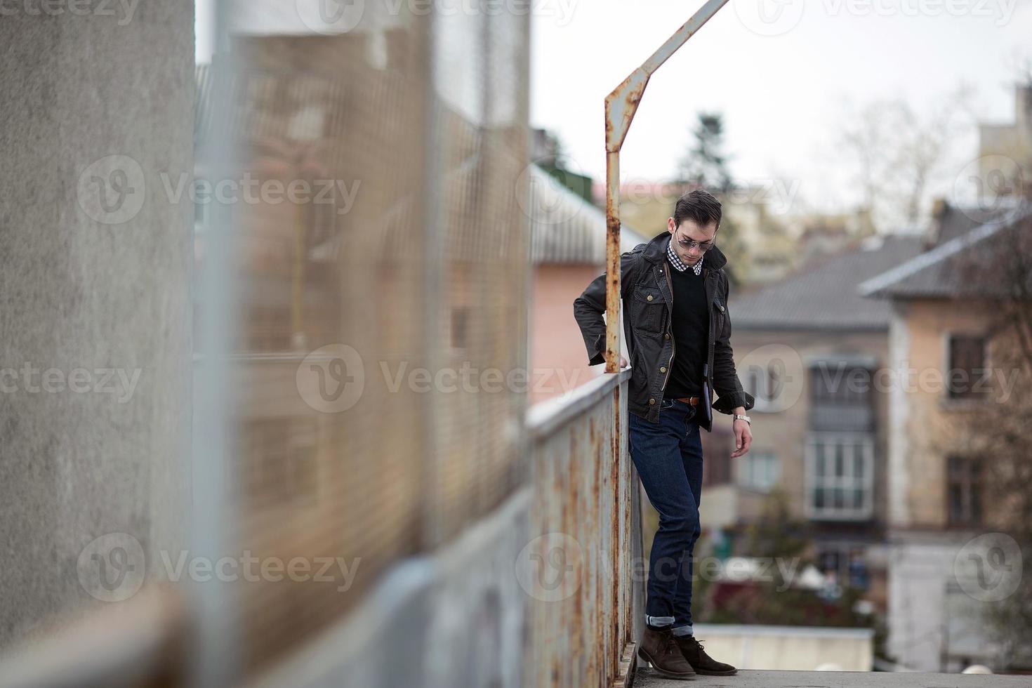 A man dressed in jeans on the background of the train and the station photo