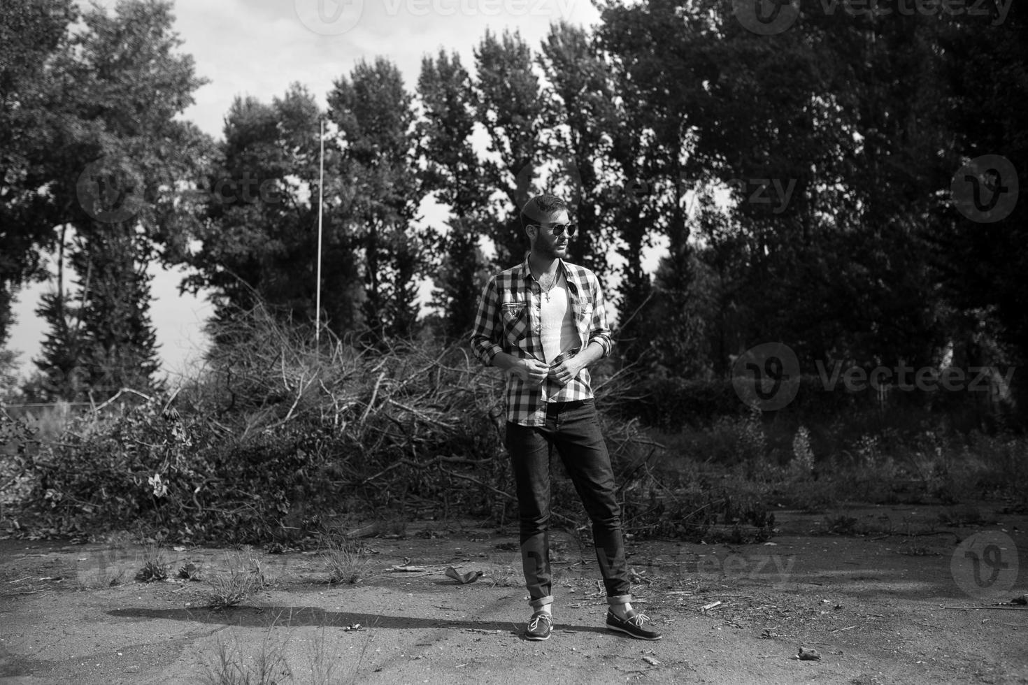 The man in the authentic boots and selvedge jeans  on a the background of branches photo