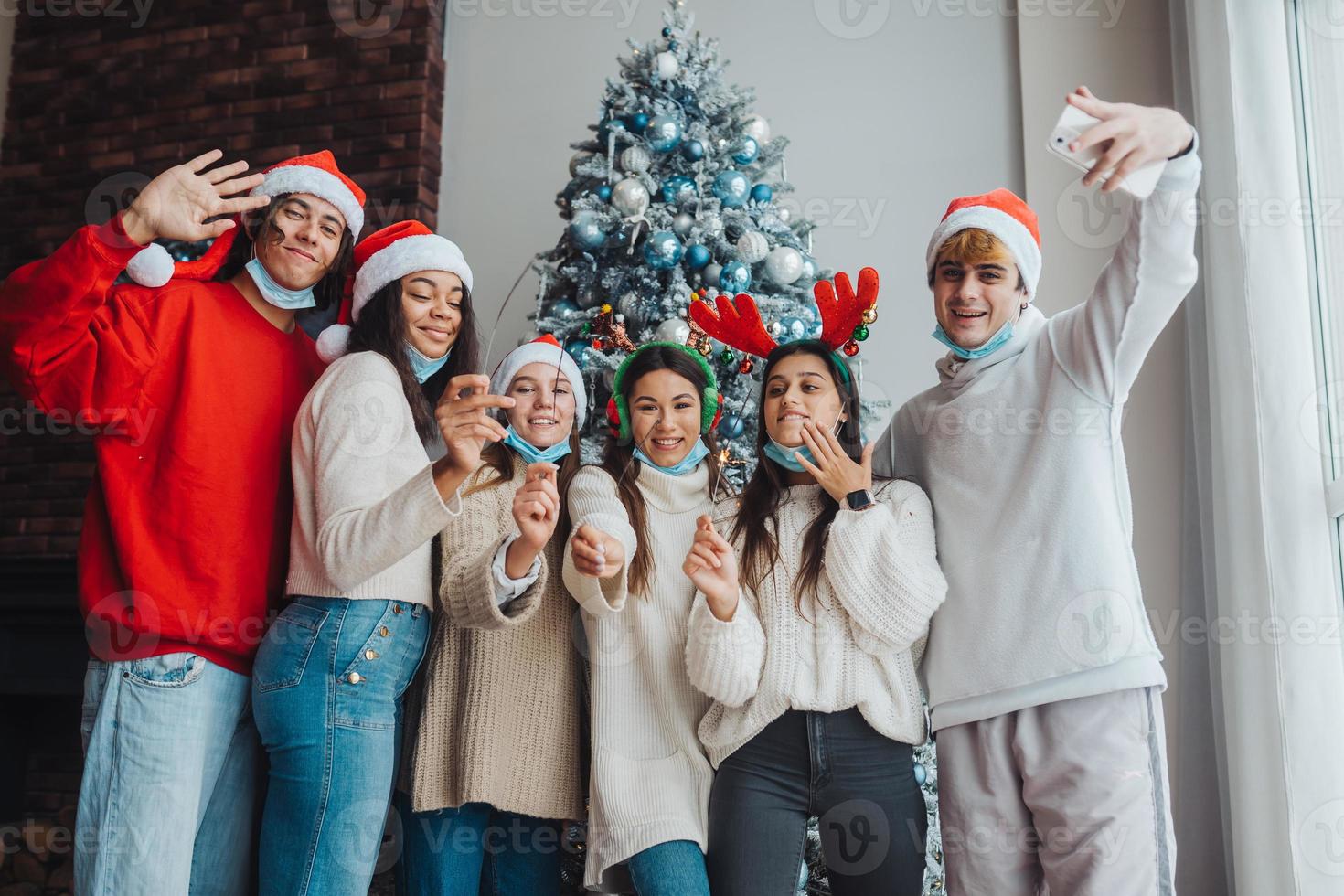 Multi-ethnic young people celebrating New year eve holding sparklers photo