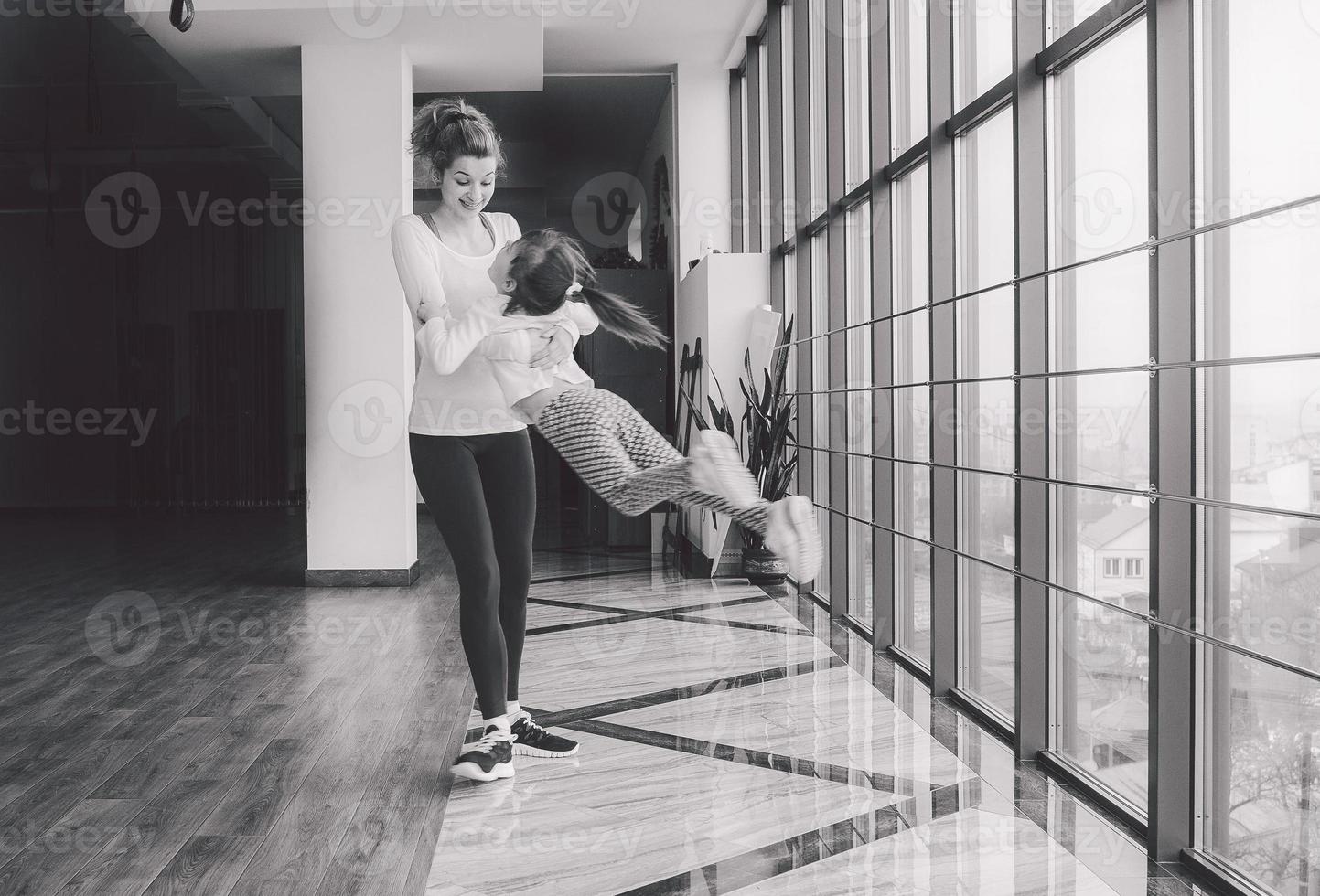 Mother twist her daughter in the gym photo