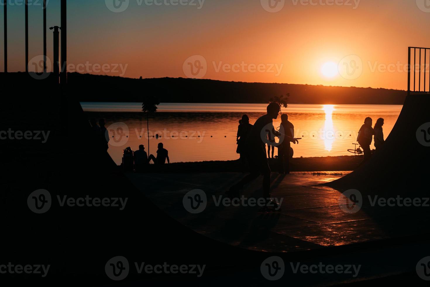 people are resting on a sports field by the river bank photo