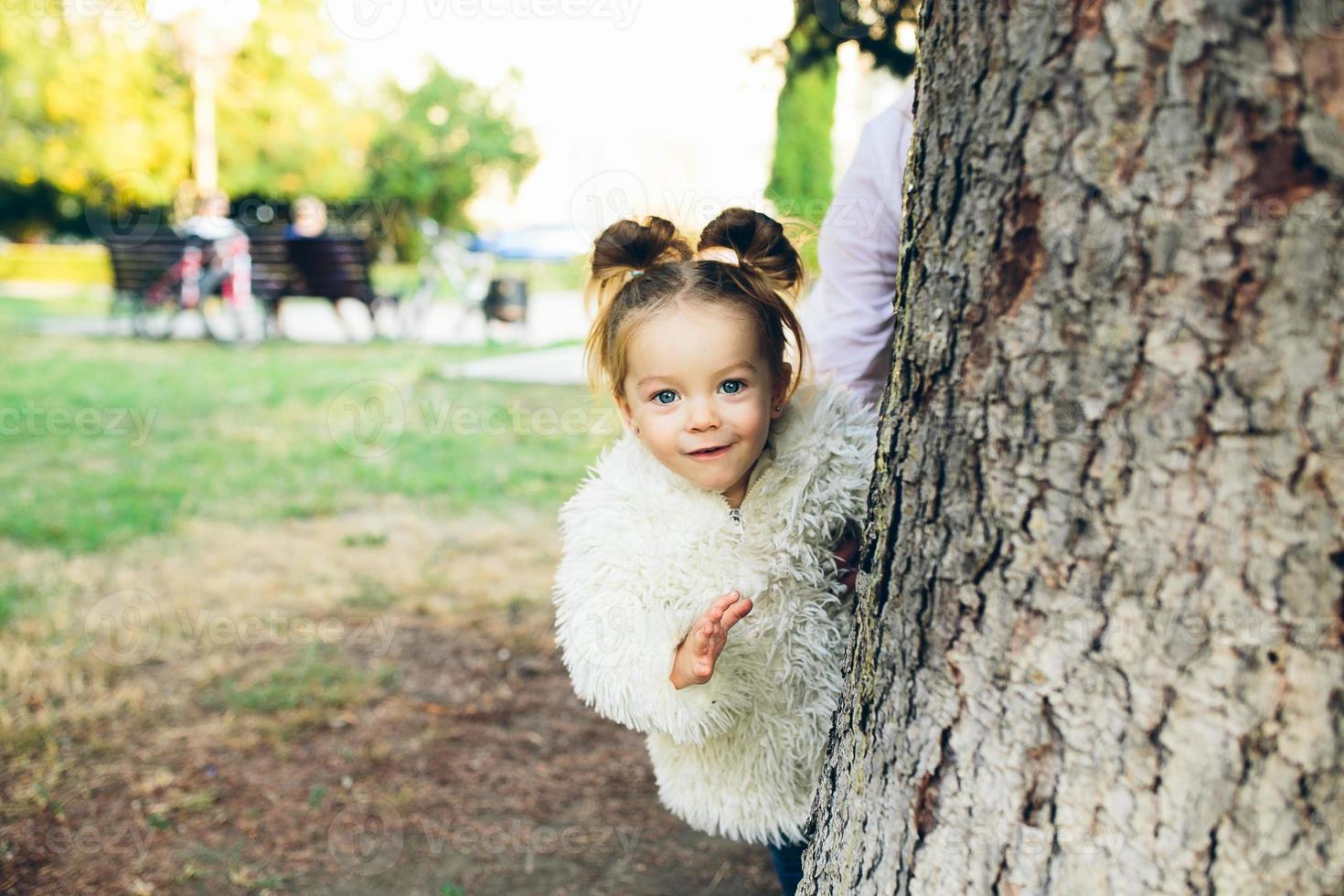 Cute little girl is playing outdoors photo