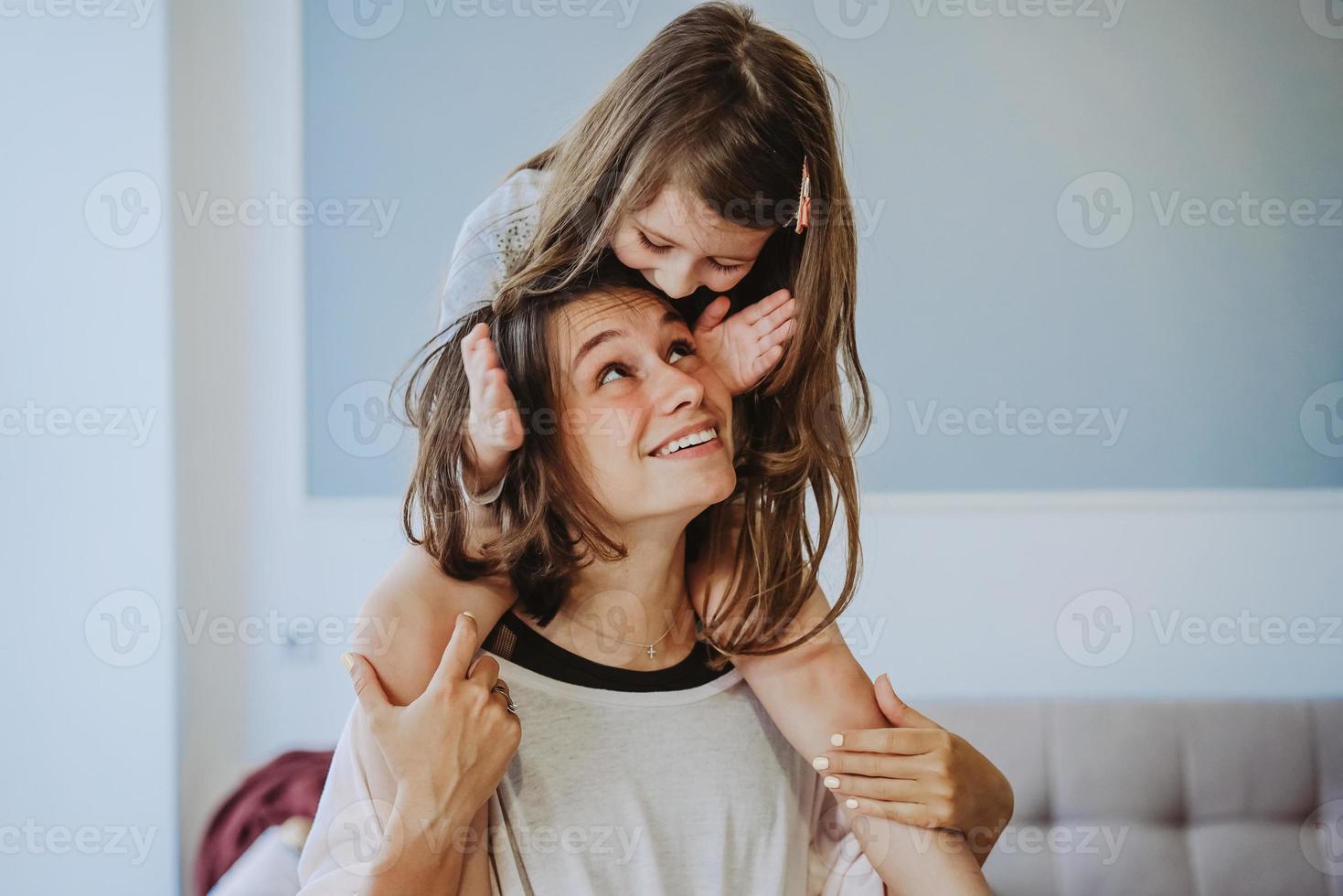 hermosa hijita que lleva a cuestas a su madre feliz foto