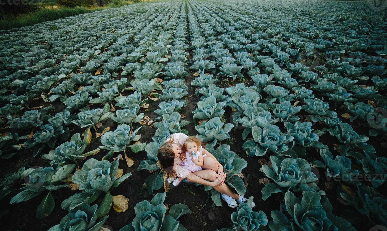 madre e hija en el campo con repollo foto