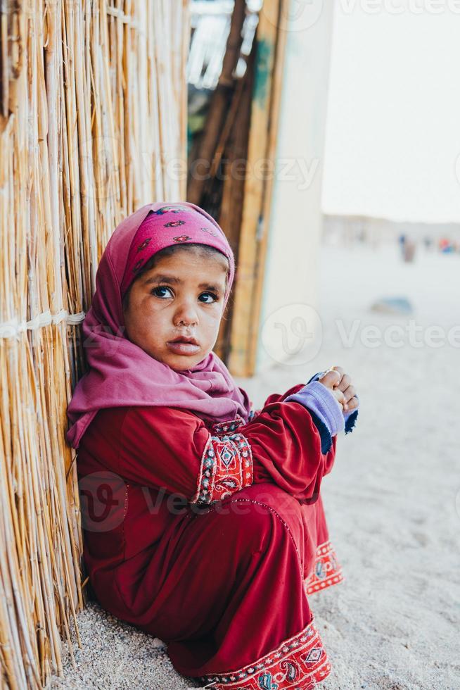 poor, sad little child girl sitting photo