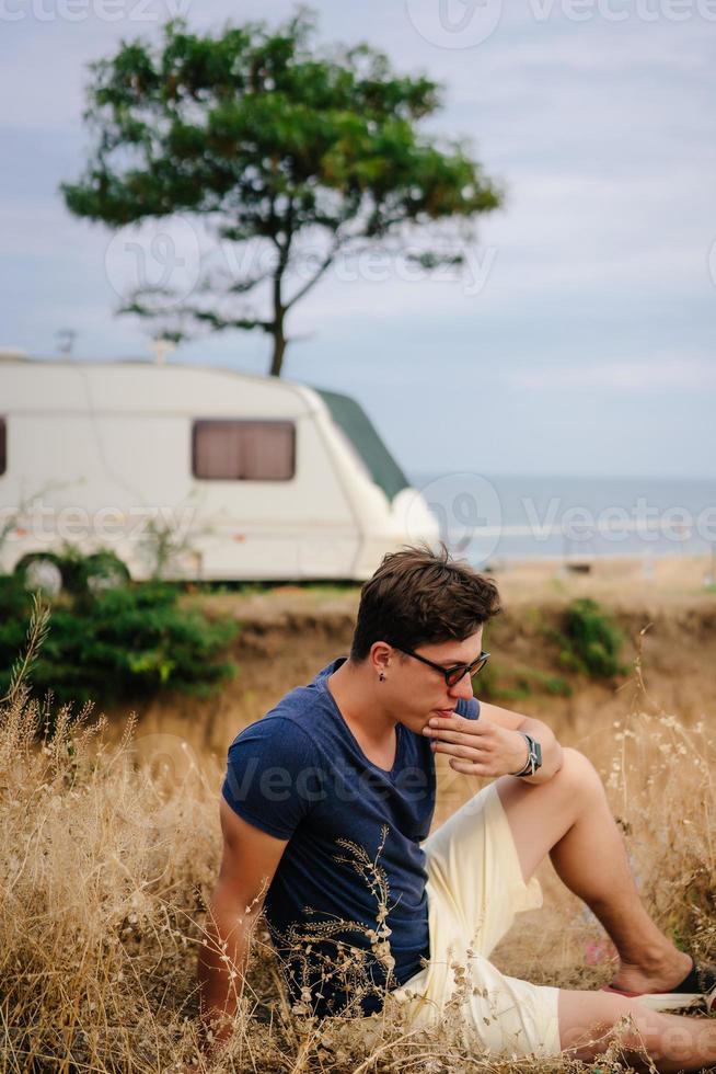 Handsome, young guy posing on a wild seashore photo
