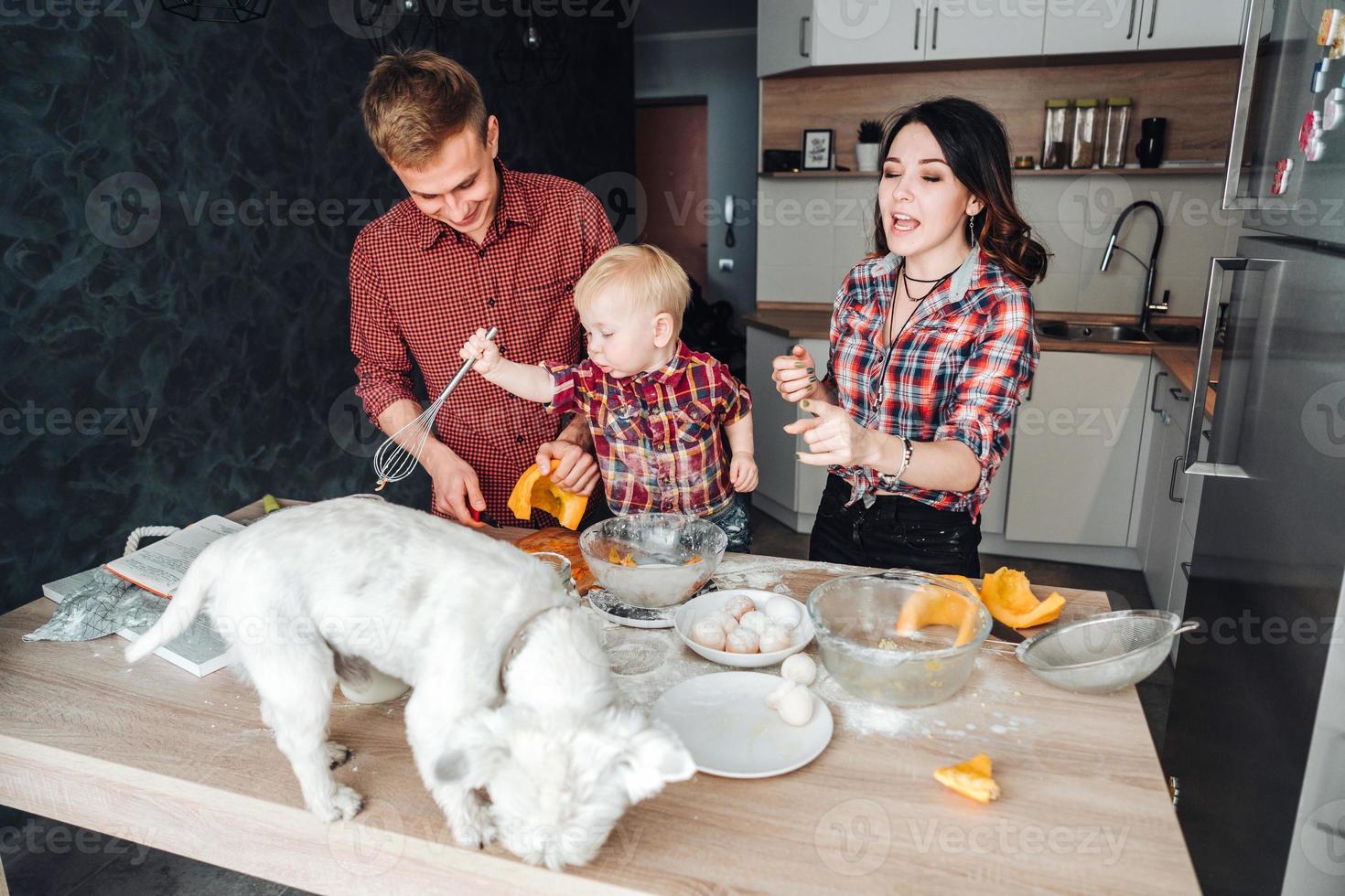 Dog on the kitchen table. Happy family in the kitchen photo