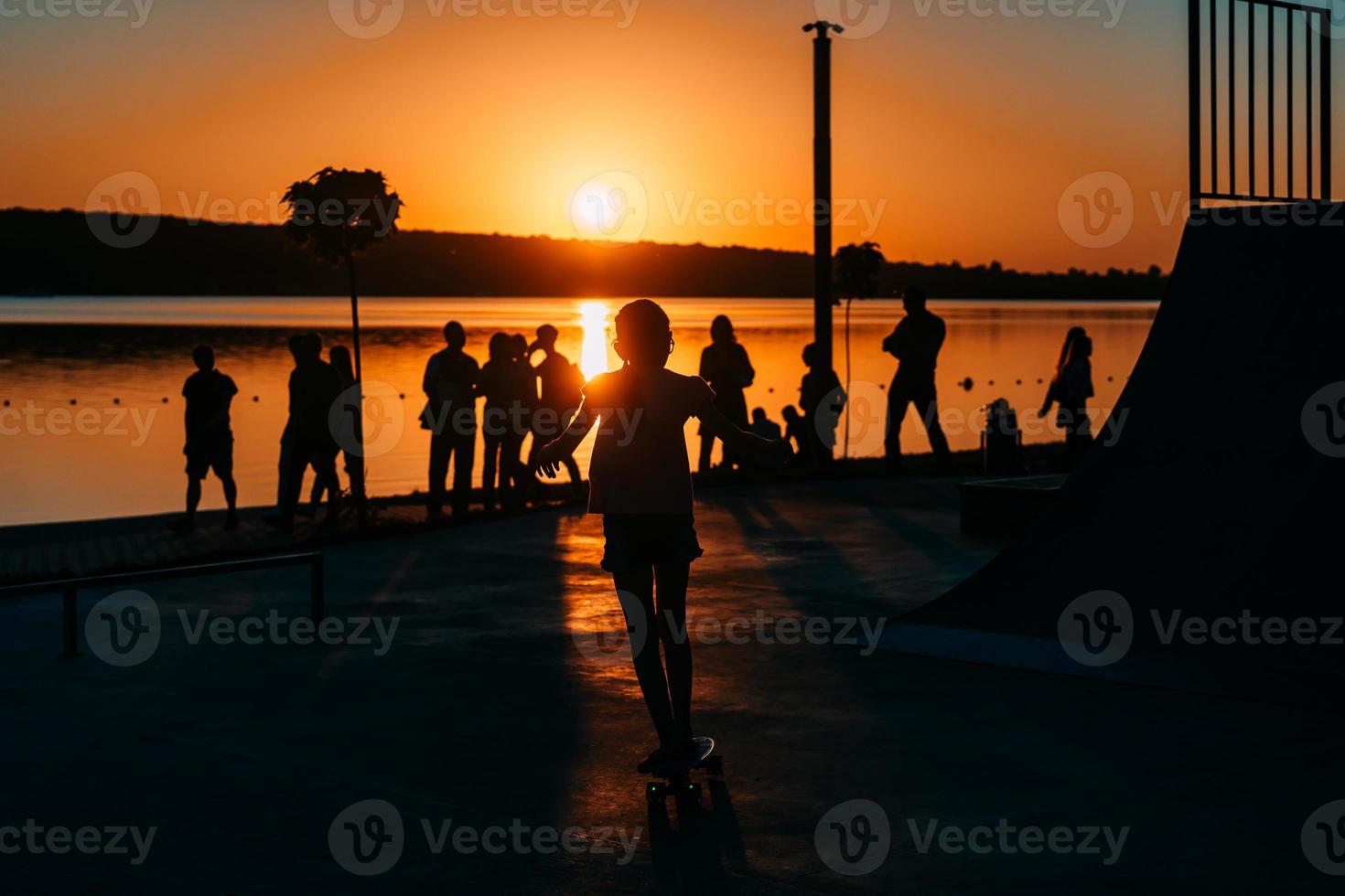 people are resting on a sports field by the river bank photo