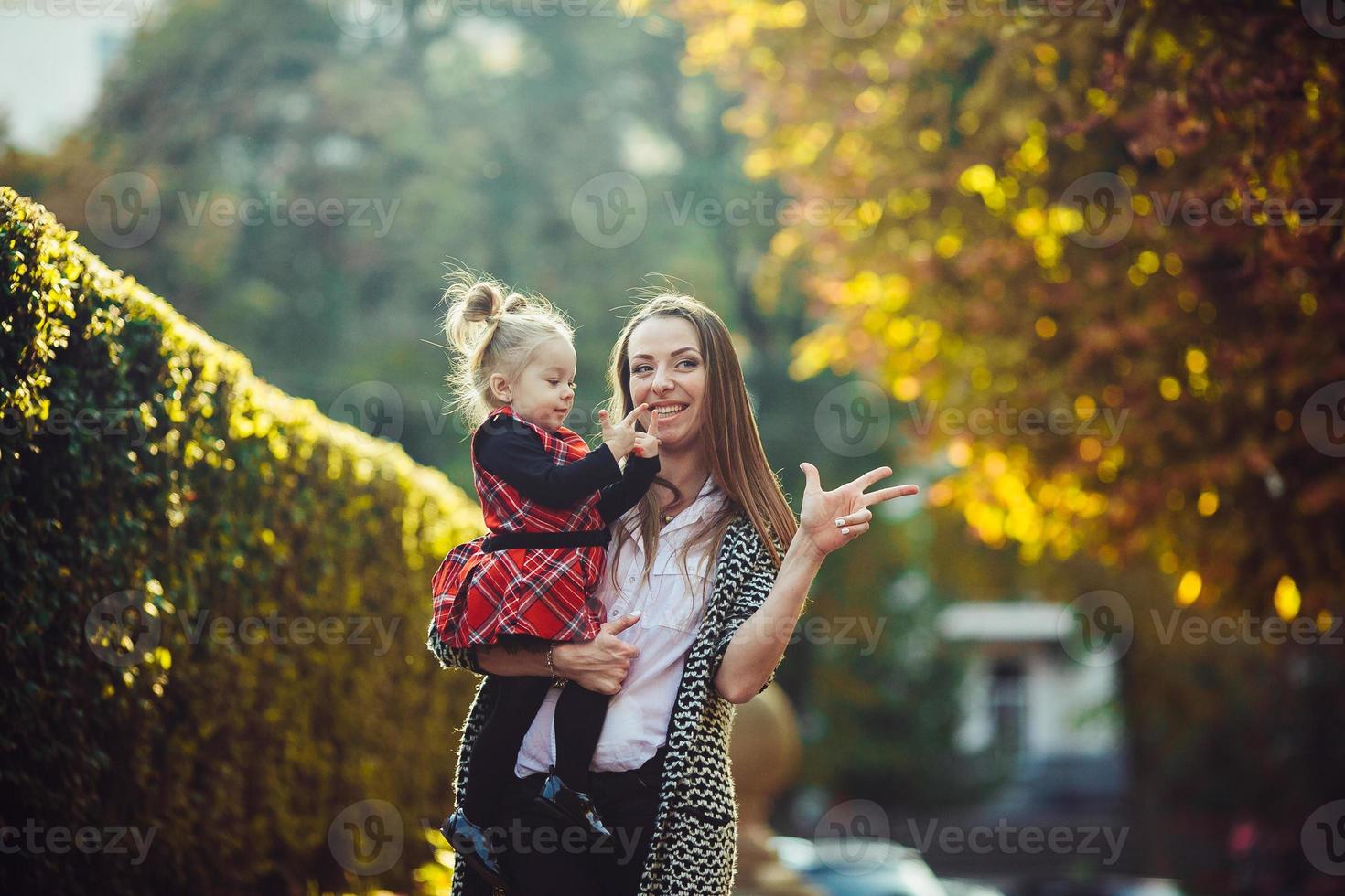 Mother and little daughter playing in a park photo