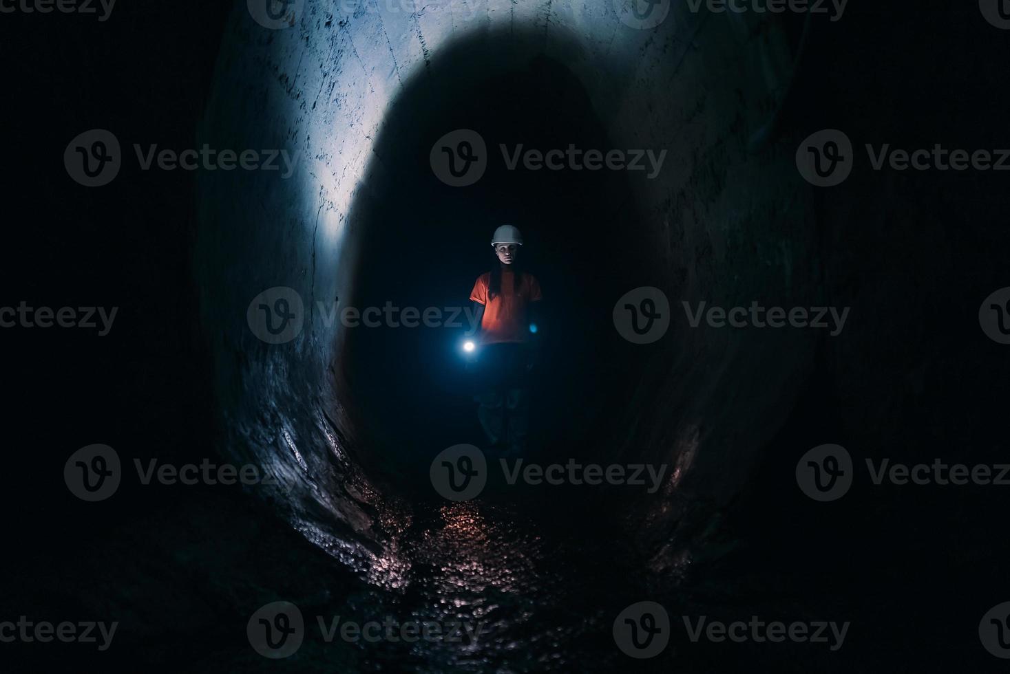 mujer excavadora con linterna explora el túnel foto