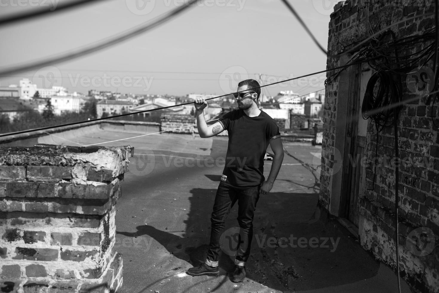 The man in the authentic boots and jeans selvedge on the roof of the building in the old town photo