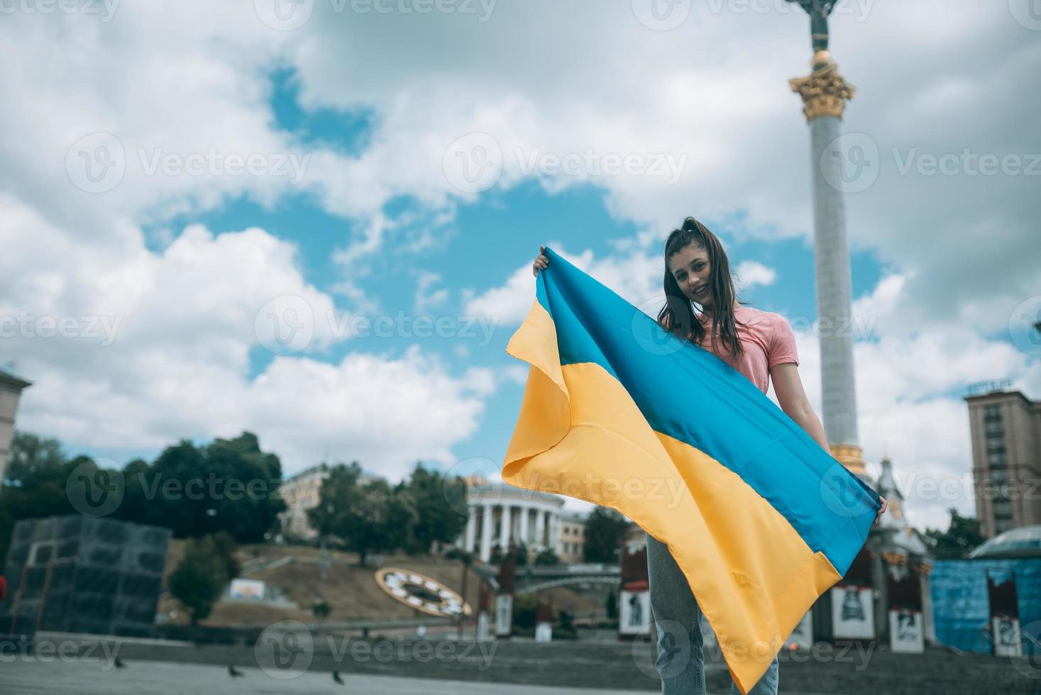 mujer joven con bandera nacional de ucrania en la calle foto