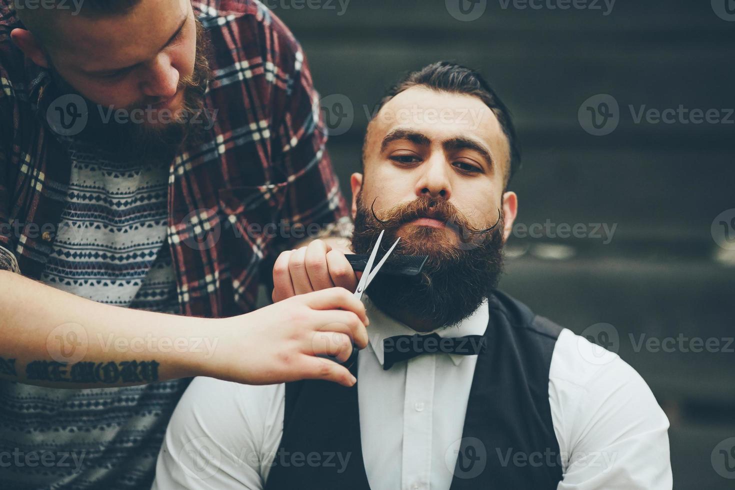 barber shaves a bearded man photo