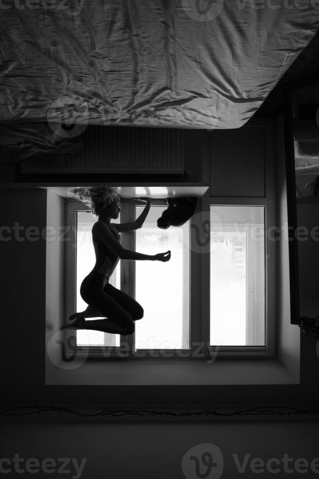 woman doing yoga asana on window sill photo