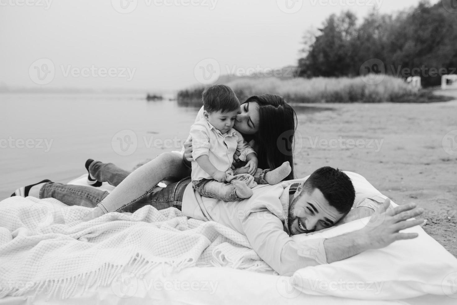 Happy young family relaxing together on the lake photo