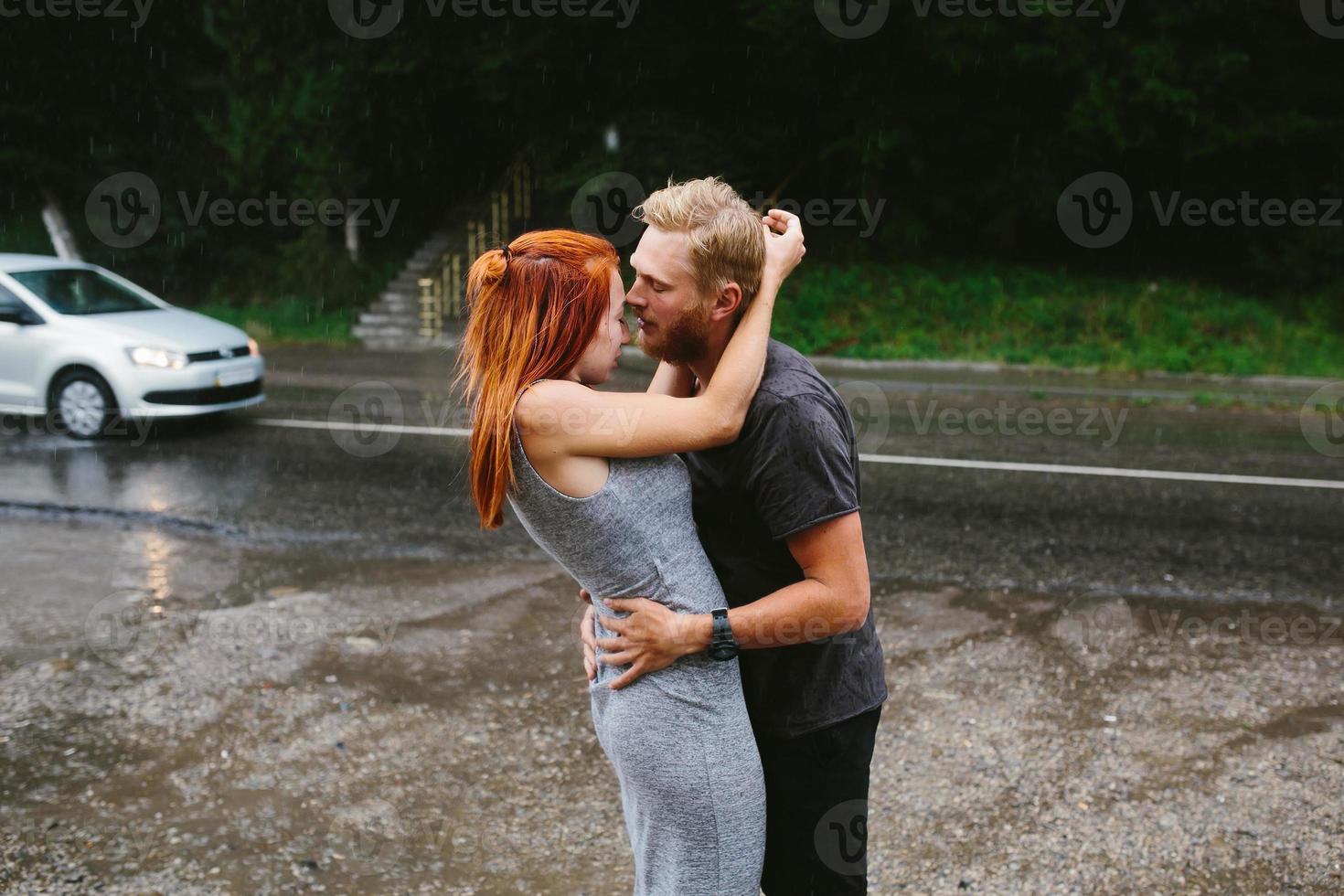 beautiful couple hugging in the rain photo