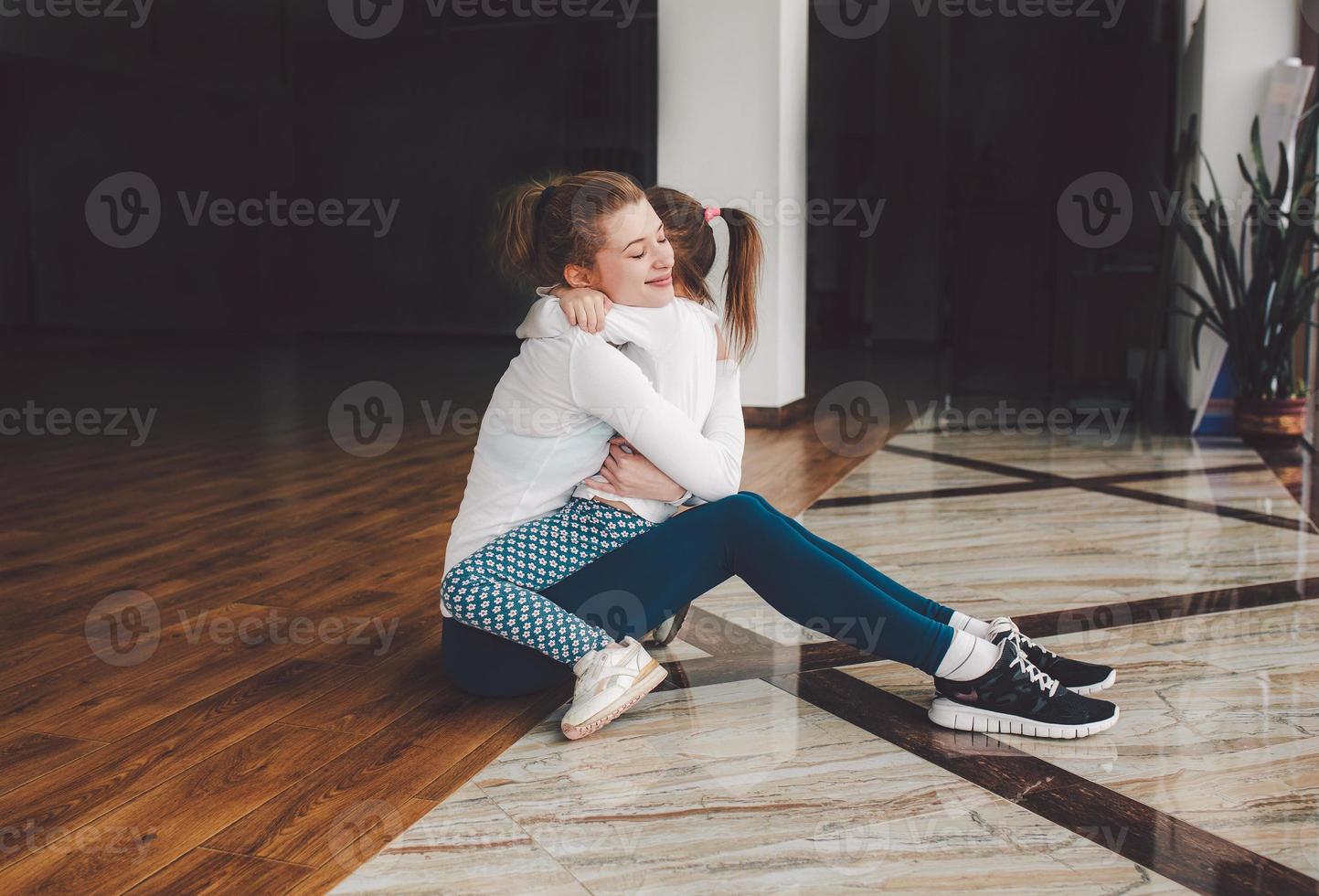 Mother and daughter hugging in the gym photo