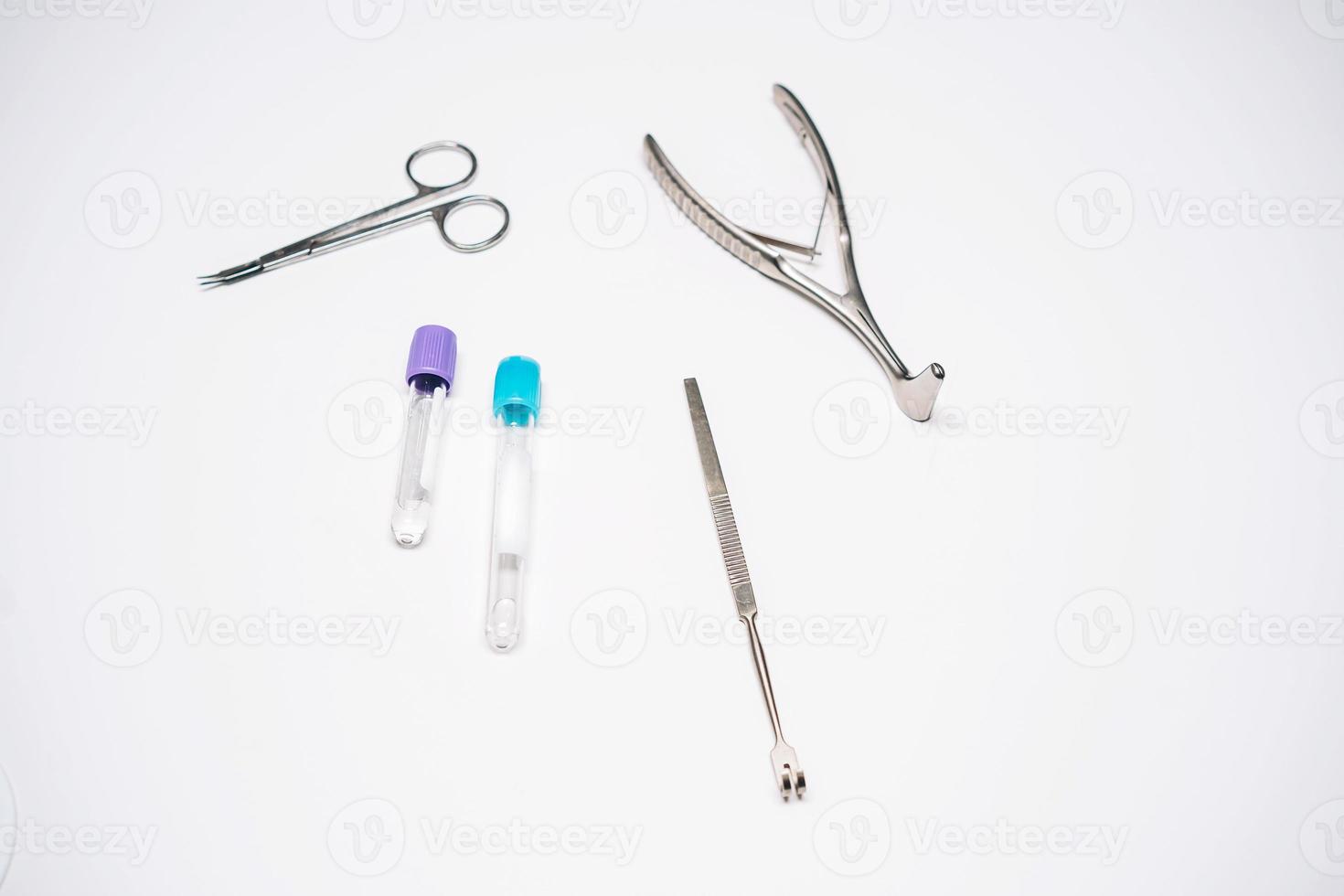 instrumentos quirúrgicos y varios tubos de ensayo yacen sobre la mesa foto
