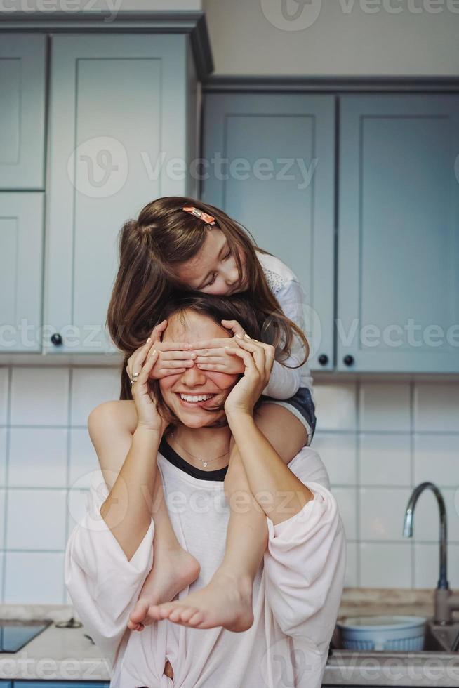 hermosa hijita que lleva a cuestas a su madre feliz foto