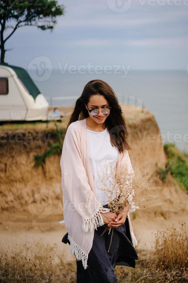 Beautiful, young girl posing on a wild seashore photo