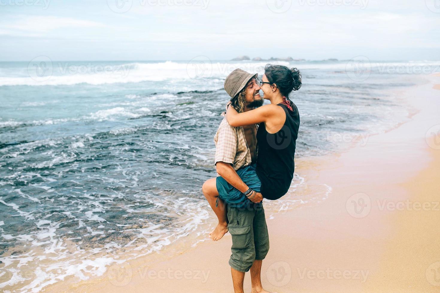 un chico y una chica se besan en la playa foto