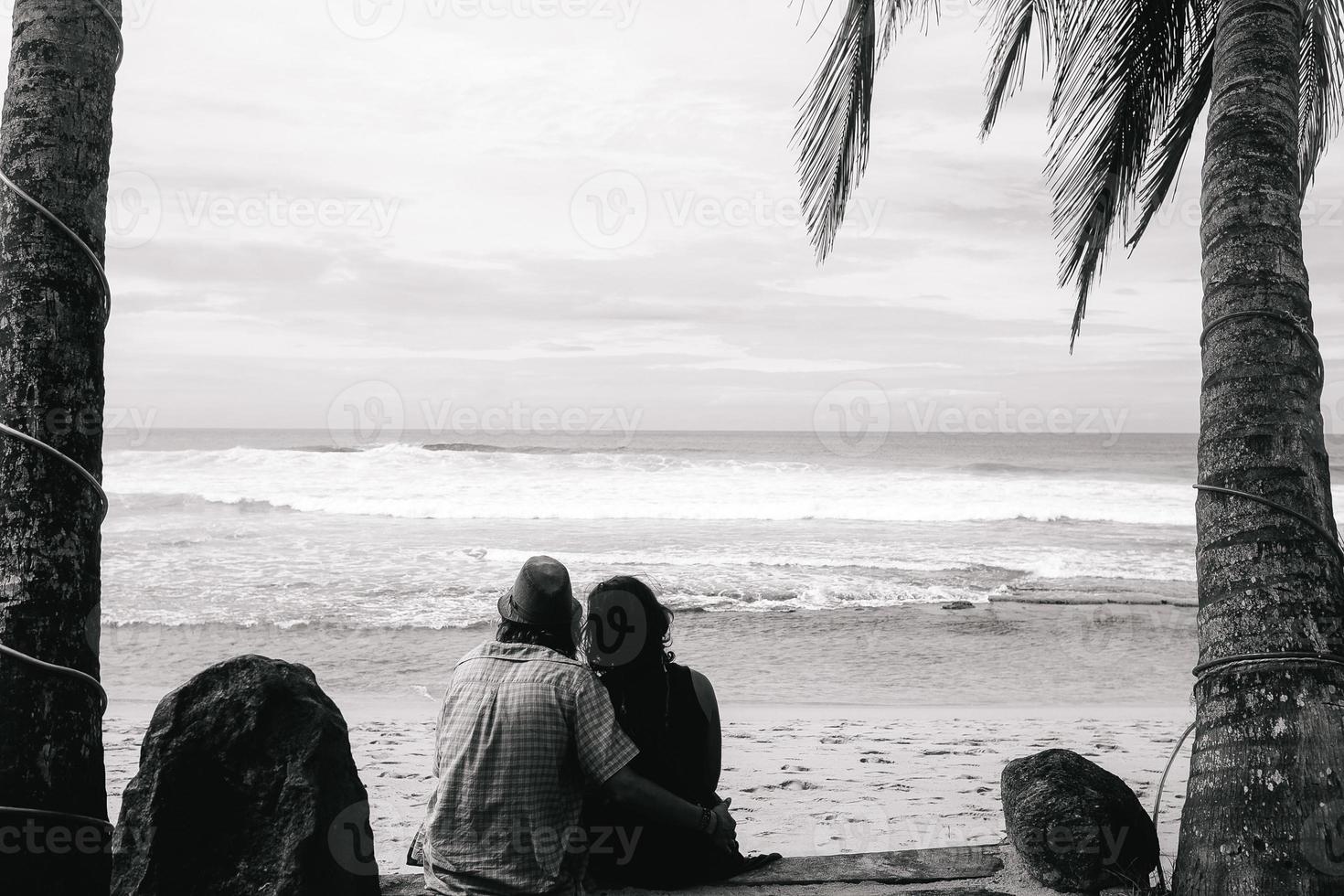 couple sitting under palm trees photo