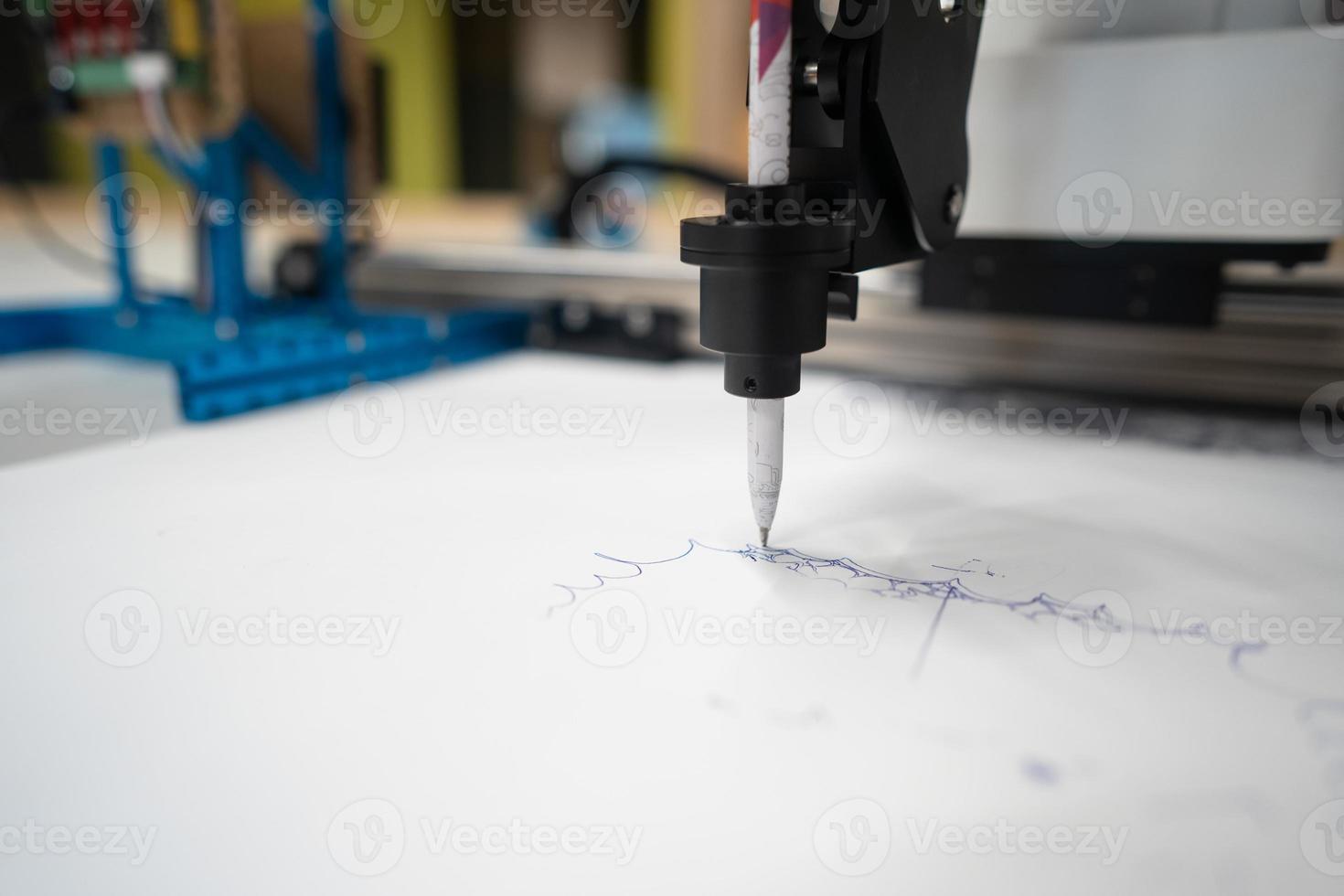 Plotter draws a pen drawing on a sheet of white paper photo