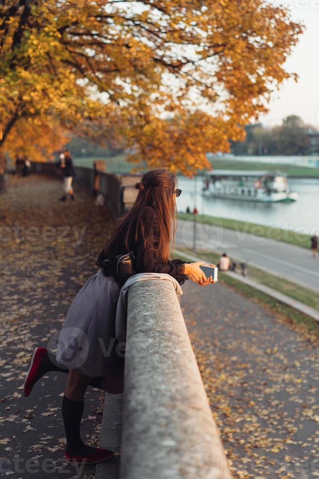 Attractive woman using smartphone outdoors in the park photo