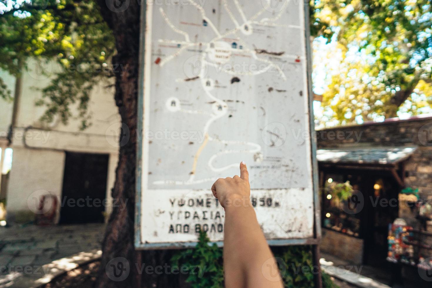Female hand, points to the map of the city. Makrinitsa photo