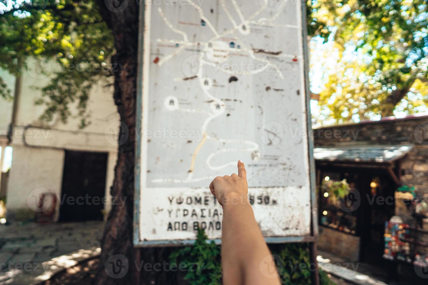 mano femenina, apunta al mapa de la ciudad. makrinitsa foto