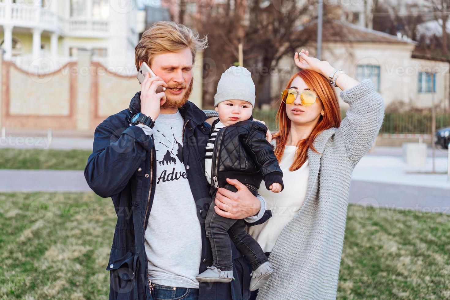 feliz mamá papá e hijo abrazándose en el parque foto