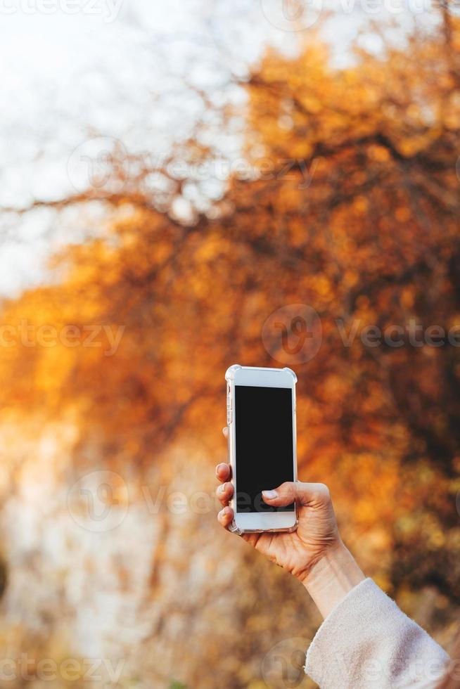 Female hand holding a phone, black screen photo
