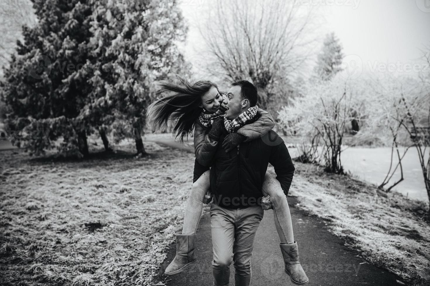 man carries his girlfriend on back photo