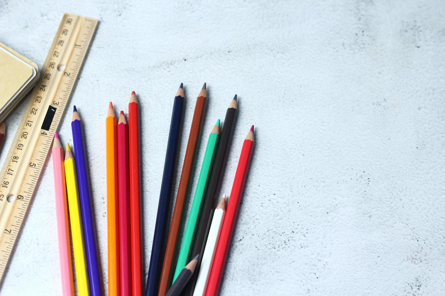 crayones de madera esparcidos sobre la mesa, reglas de madera y cuadernos con el festival de regreso al semestre, los estudiantes van a la escuela, clases de arte. foto