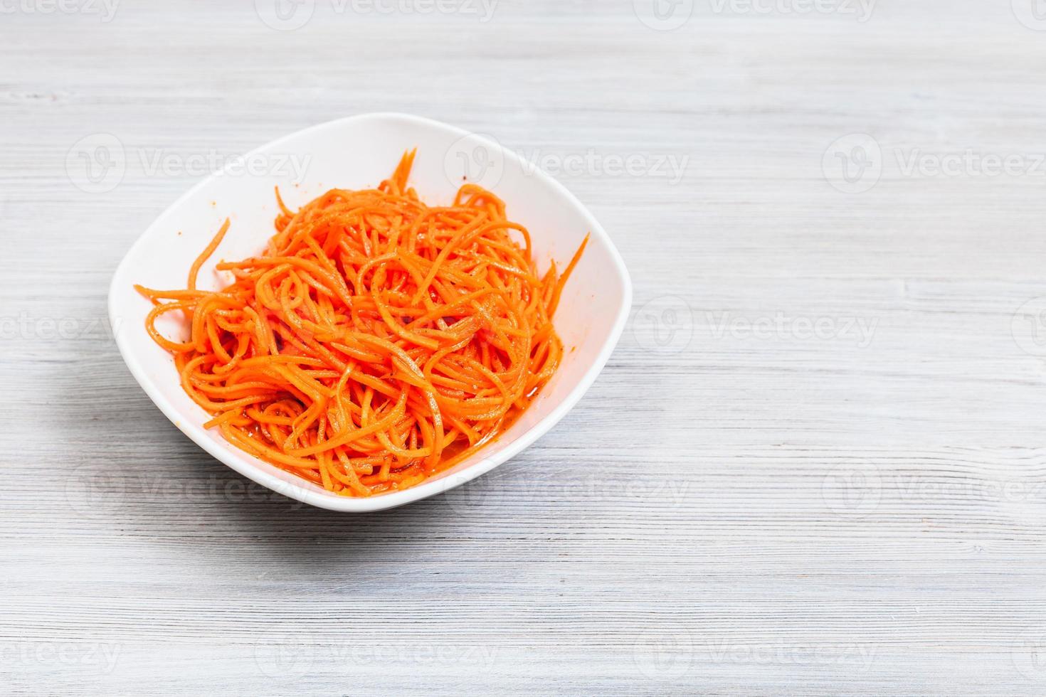 Koryo-saram spicy carrots in bowl on gray table photo