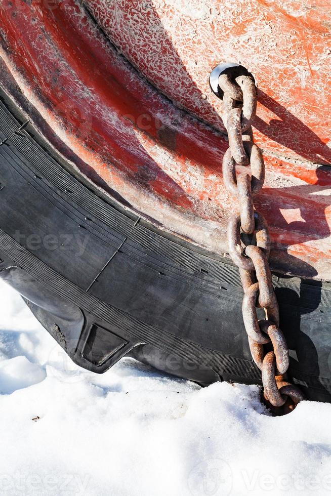 rusty snow chain fitted to tractor wheel photo