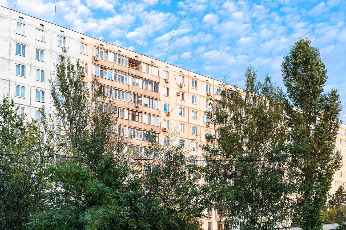 sunlit residential multi-storey building and trees photo