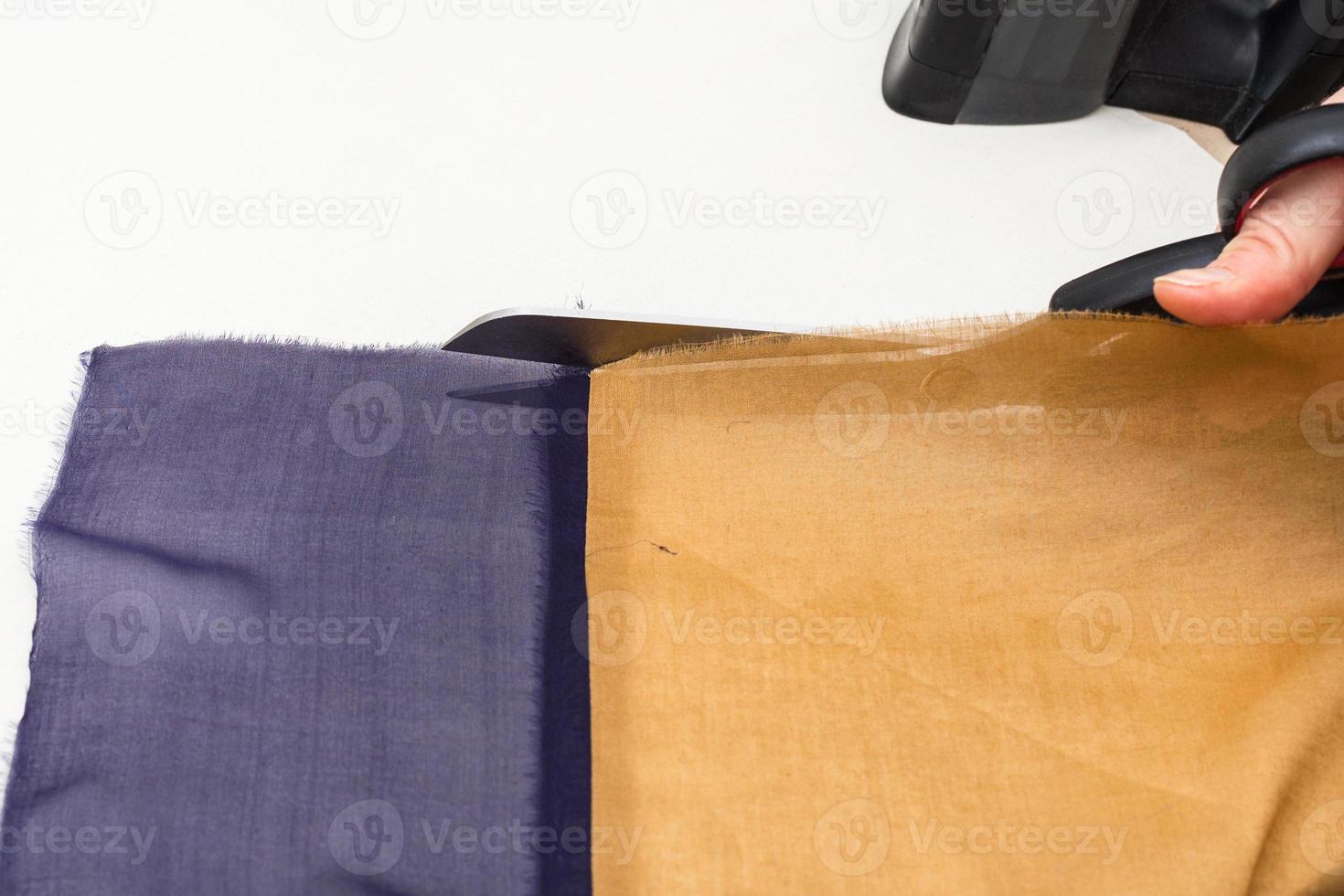 designer cuts the strips of fabrics by scissors photo