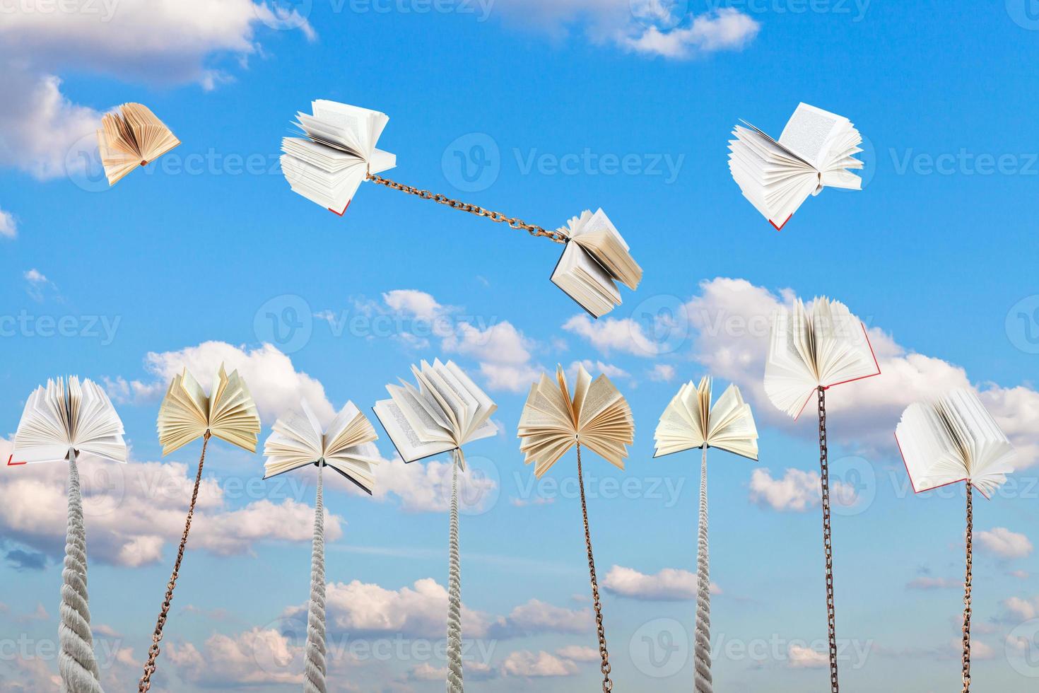 set of book tied on ropes and chains with blue sky photo