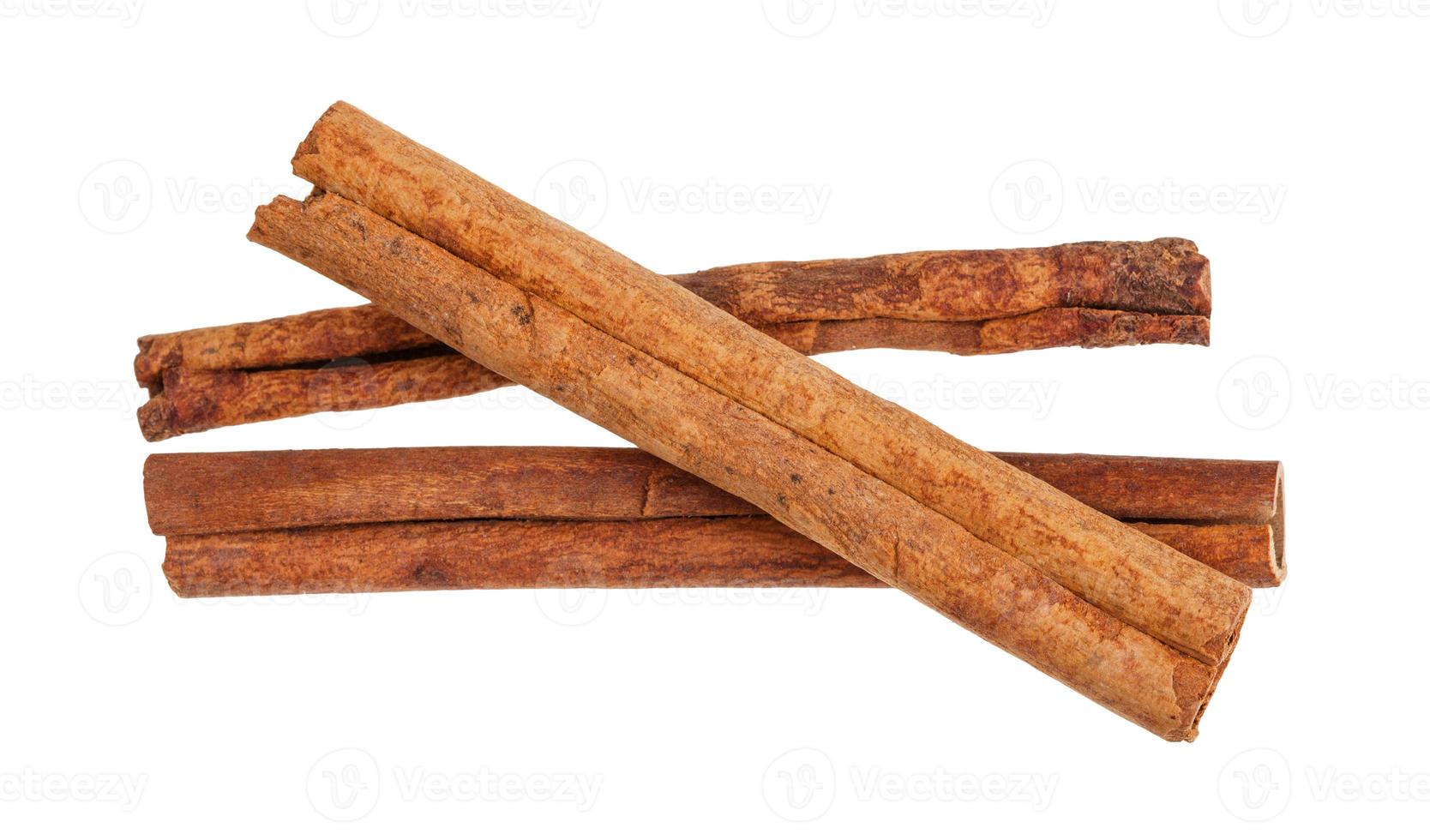 three rolled dried Cinnamon sticks isolated photo