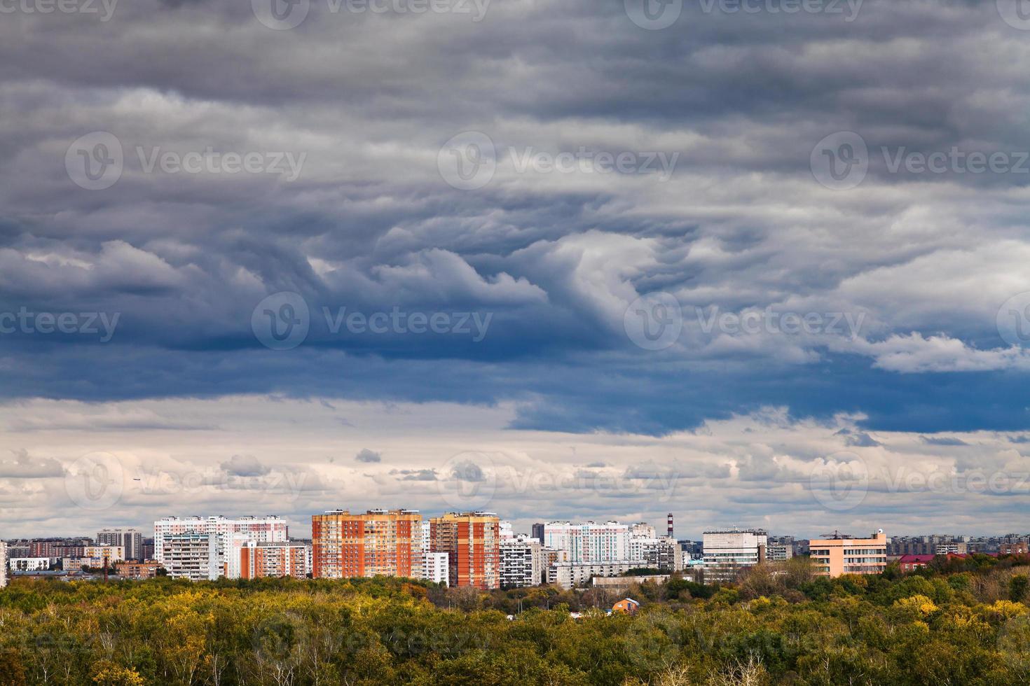 dark blue rainy clouds over city in autumn photo