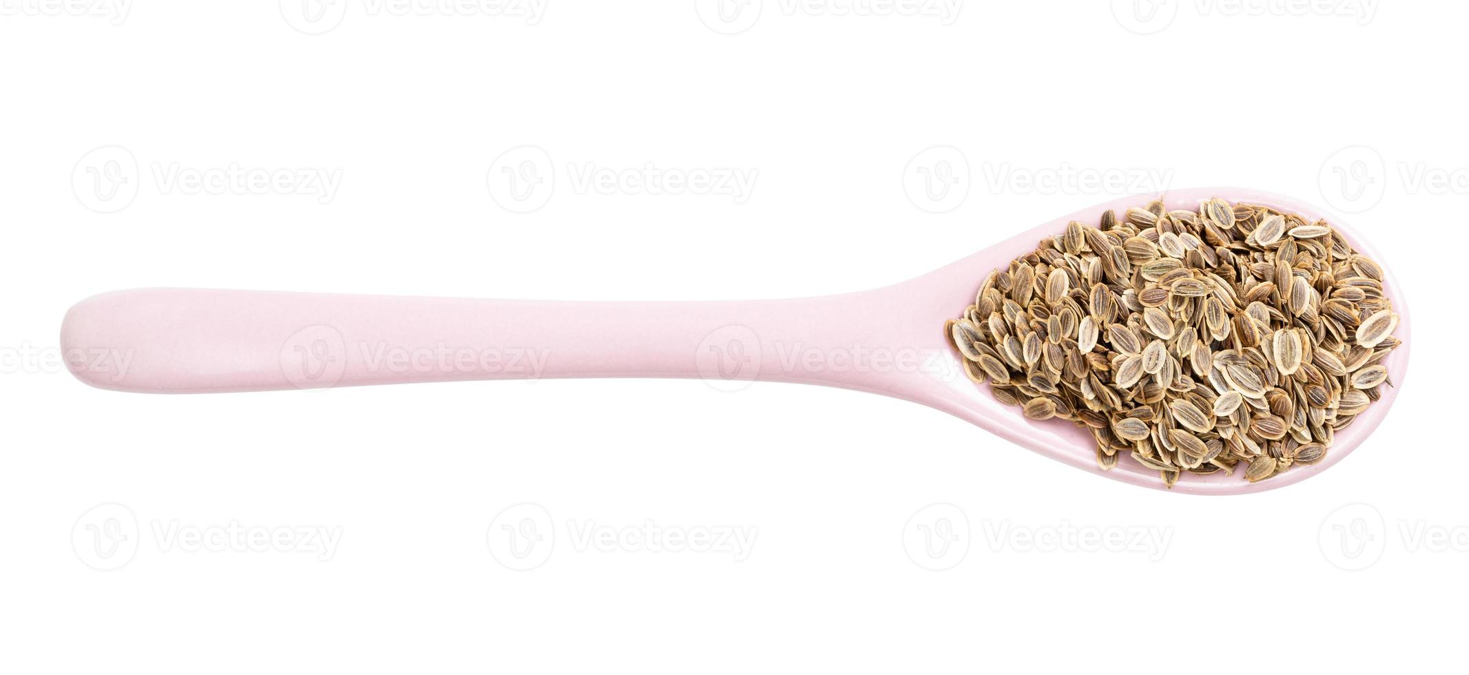 top view of ceramic spoon with dill seeds isolated photo