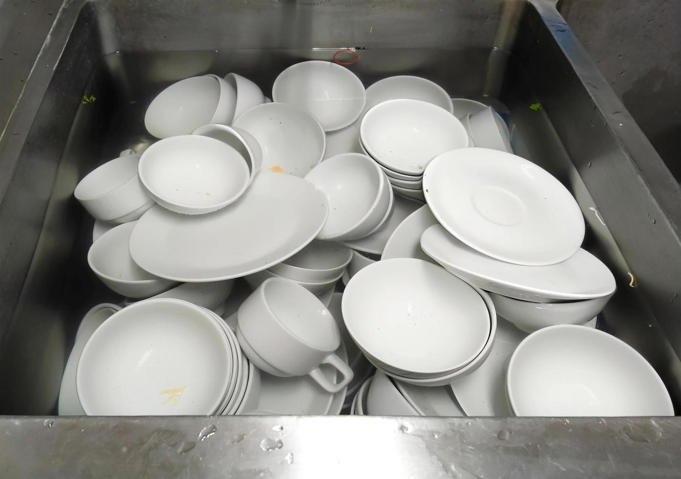 Top view many dirty dishes in kitchen sink photo