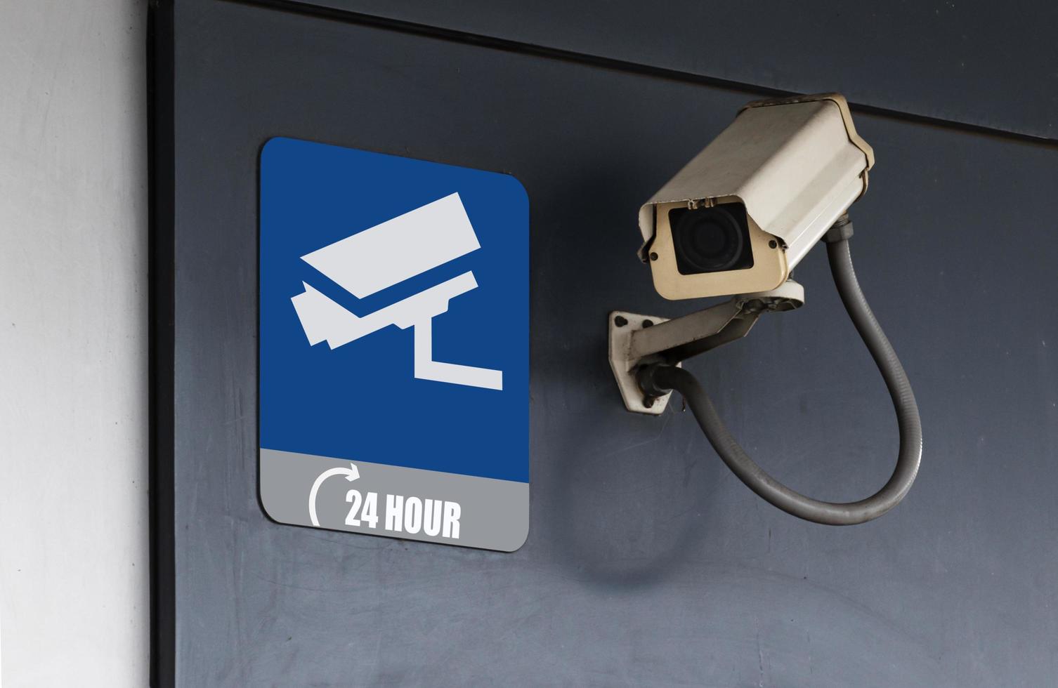 Outdoor white CCTV on wall building with sign icon camera CCTV and message 24 HOUR photo