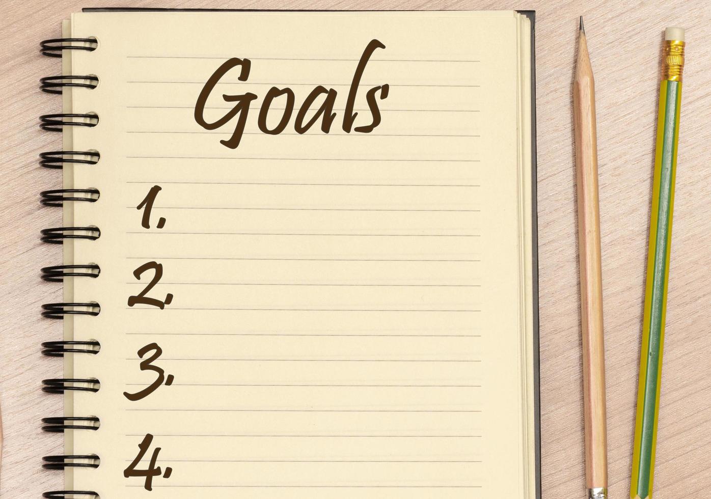 Top view notebook write message Goals and number list with pencil on table photo