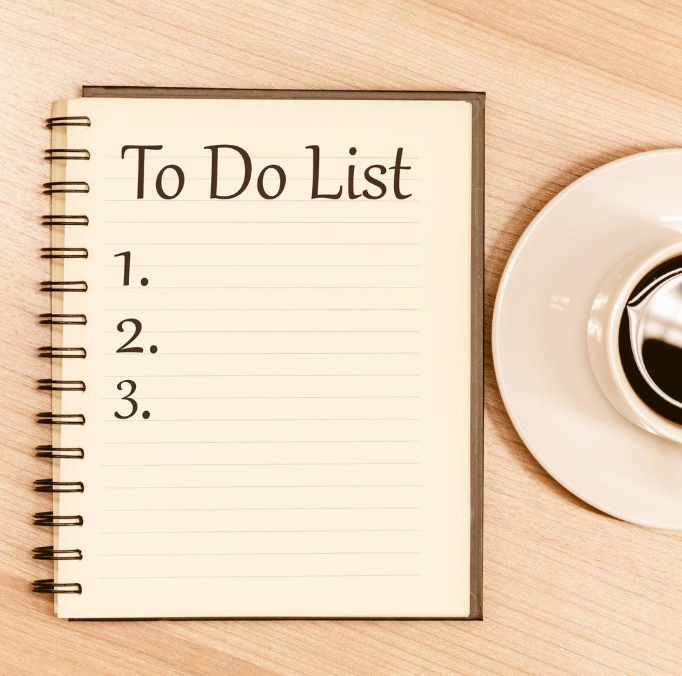 Top view notebook write message To Do List and number list with coffee cup on table photo