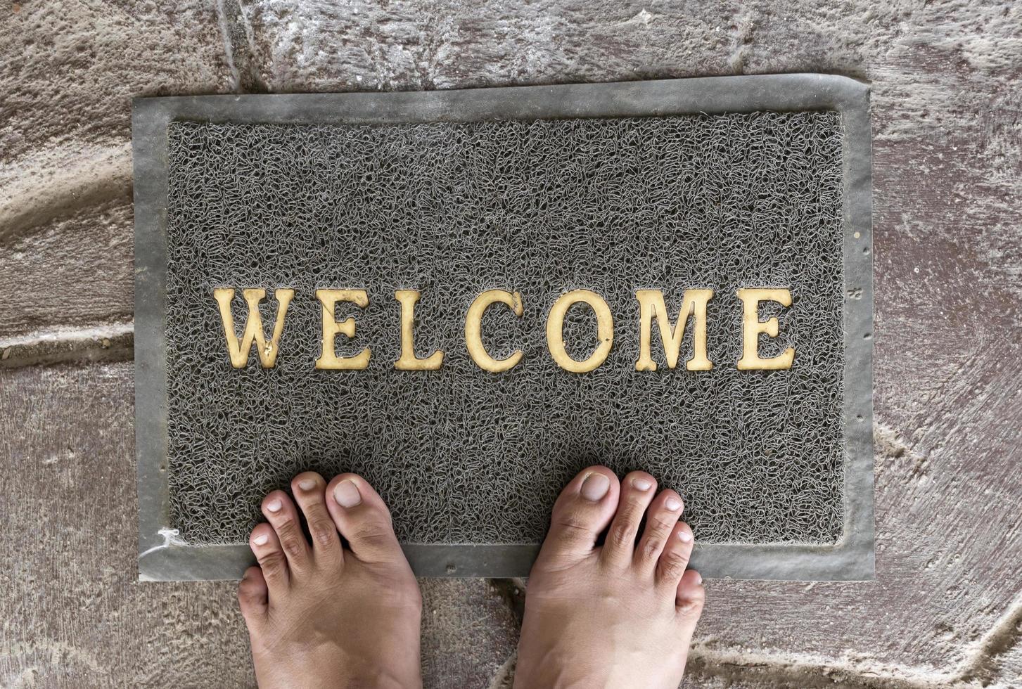 Top view of foot on welcome mat photo