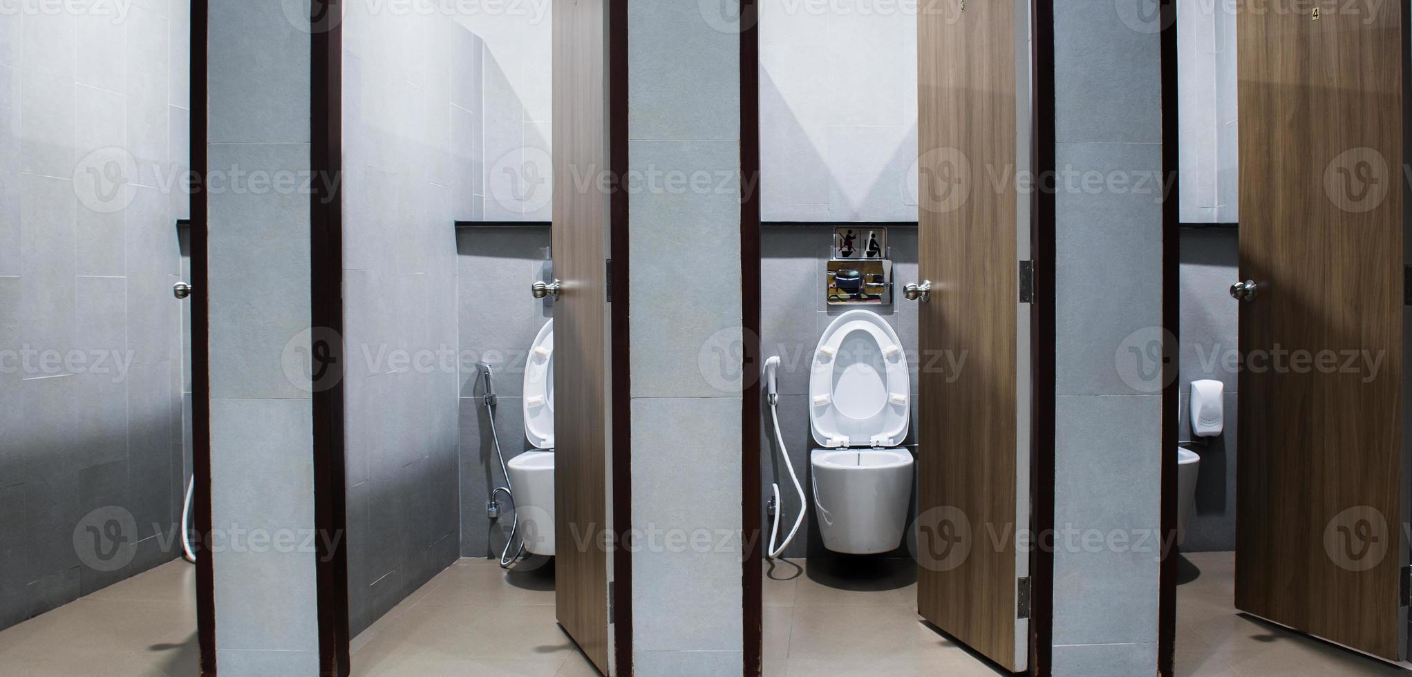 Modern public toilet with ceramic white toilet bowl with grey wall photo