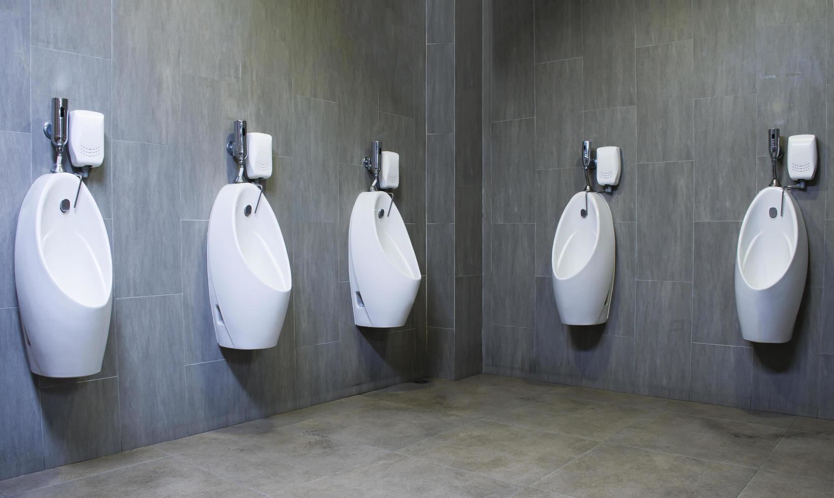 baño de hombres con urinarios de porcelana blanca en línea foto